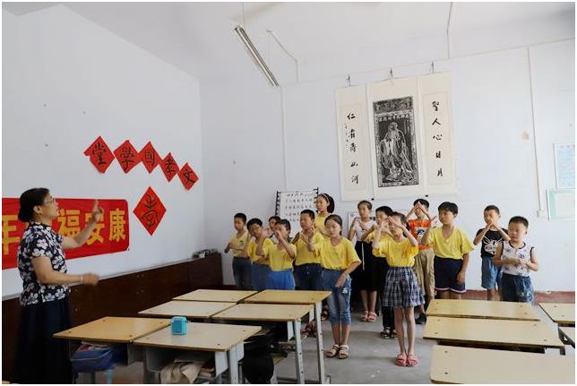 她在村里义务开了个国学堂班，照片为张晓慧教孩子学习《习主席寄语》手语表演.jpg